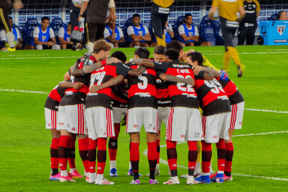 Jogadores do Flamengo reunidos em círculo no gramado do Maracanã antes da partida