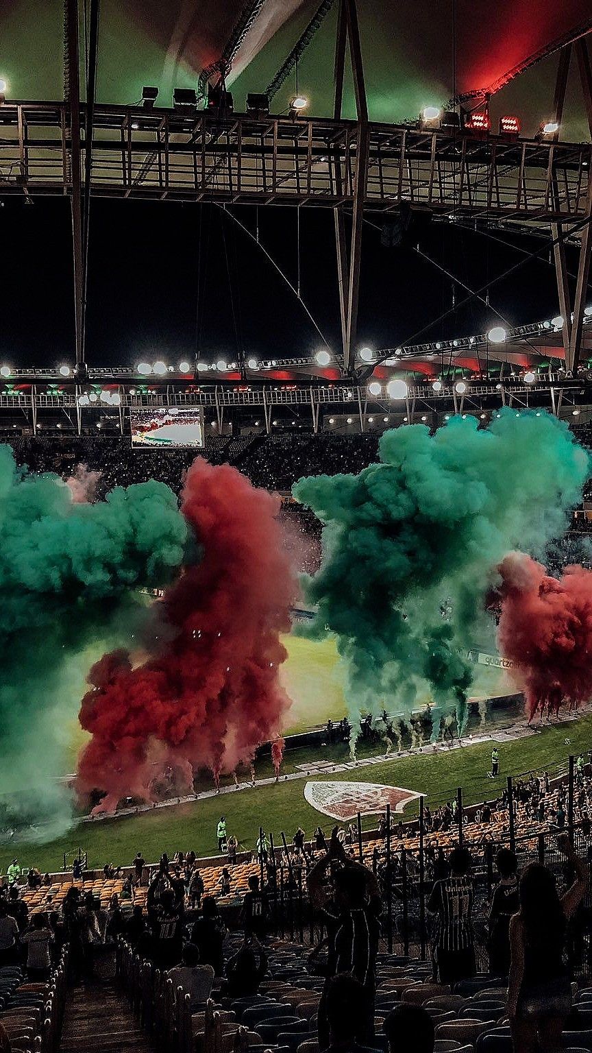 Torcida do Fluminense com sinalizadores verdes e grenás na arquibancada do Maracanã